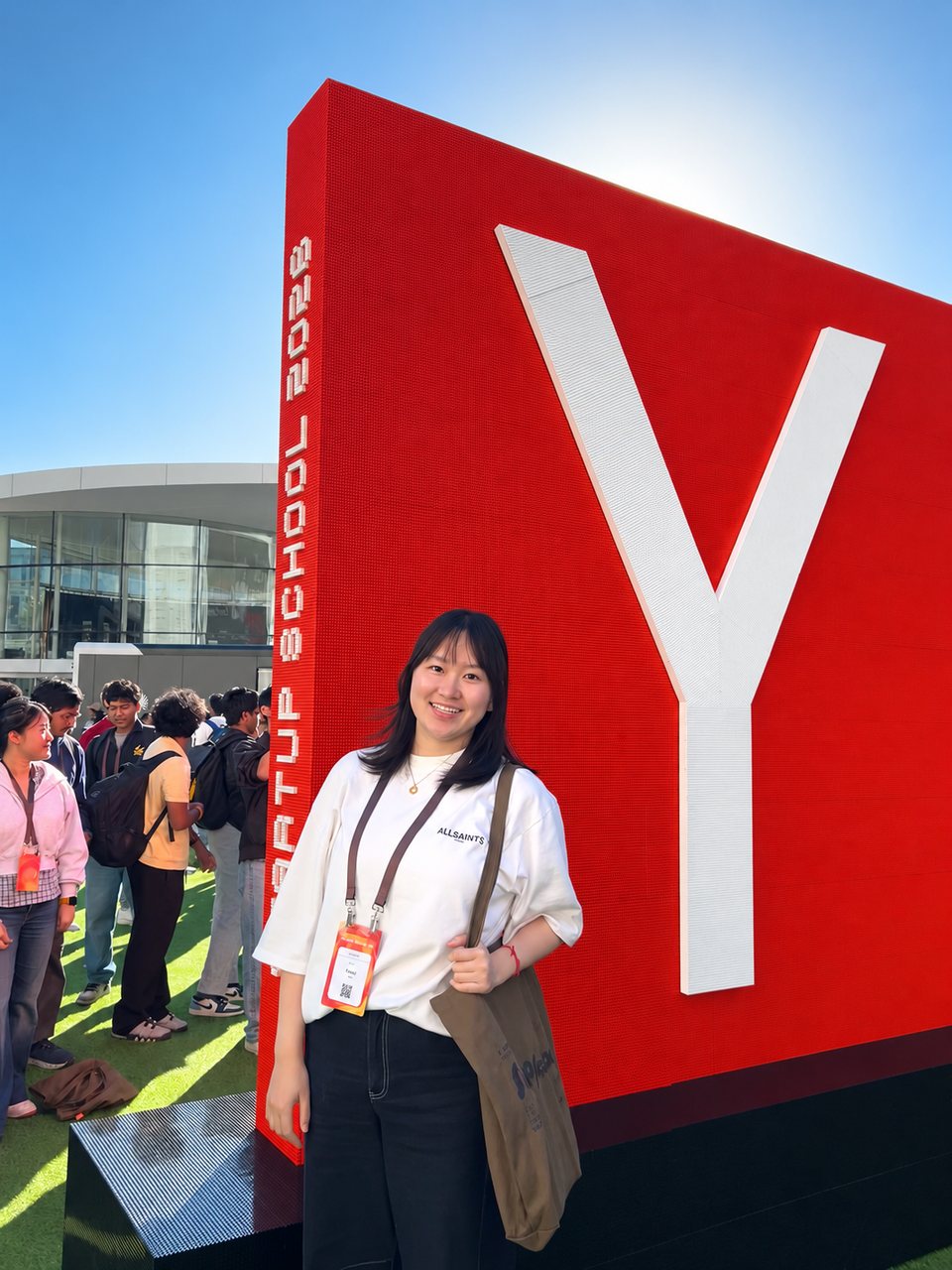 Yanqi Luo in front of the Y Combinator Startup School sign